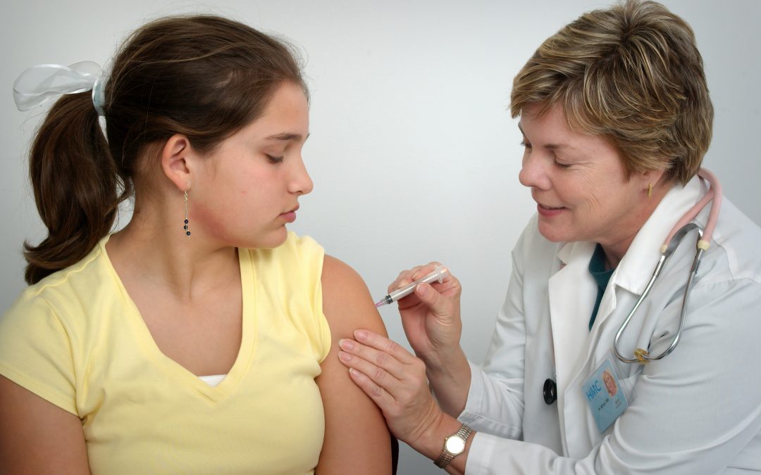 woman injecting girl's left arm